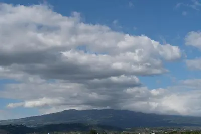 a cloudy sky with a mountain in the background at Nice private apartment studio to discover CR in Alajuela City