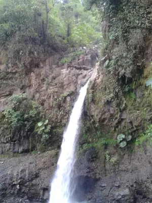 a waterfall on the side of a rocky mountain at Nice private apartment studio to discover CR in Alajuela City