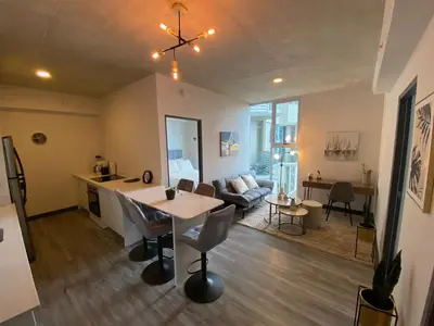 a kitchen and living room with a table and a couch at Cómodo y elegante apartamento en fabuloso condo! in San José