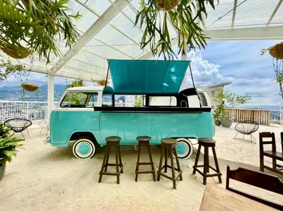 an old truck with a table and stools at Cómodo y elegante apartamento en fabuloso condo! in San José