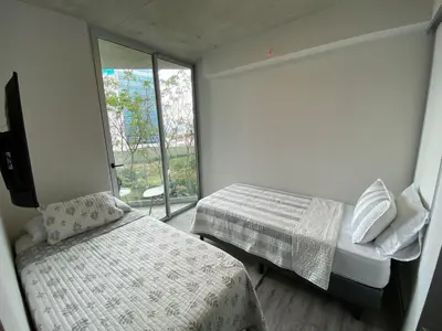 a small bedroom with two beds and a window at Cómodo y elegante apartamento en fabuloso condo! in San José