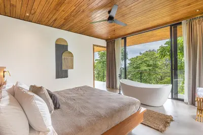a bedroom with a bed and a tub and a window at Villa Lasai - Brand New Villa Luxury Villa in Carmen