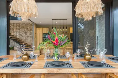 a dining room table with glasses and a vase of flowers at Villa Lasai - Brand New Villa Luxury Villa in Carmen