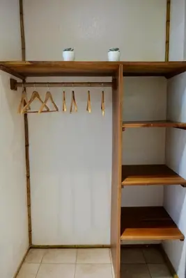 a closet with wooden shelves and hangers at TERMINAL VERDE PRIVATE APARTMENTS NEAR AIRPORT 24h SELF CHECK IN in Concepción