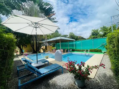 a pool with a chair and an umbrella at Hotel La Fiore de Bahia in Uvita
