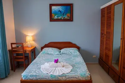 a bedroom with a bed with a flower on it at Hotel La Fiore de Bahia in Uvita