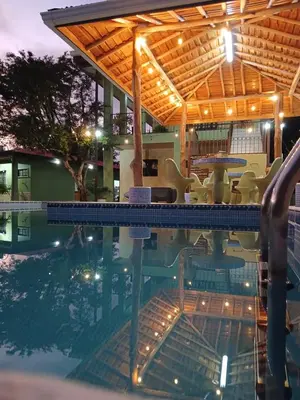 a view of a pool with a table and chairs at Hotel La Fiore de Bahia in Uvita