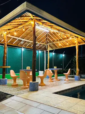 a pavilion with tables and chairs and a pool at Hotel La Fiore de Bahia in Uvita