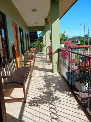 a porch with benches and flowers on a building at Hotel La Fiore de Bahia in Uvita