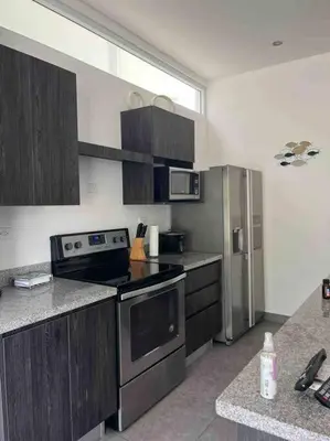 a kitchen with a stove and a refrigerator at Lapa Lodge G1 in Jacó