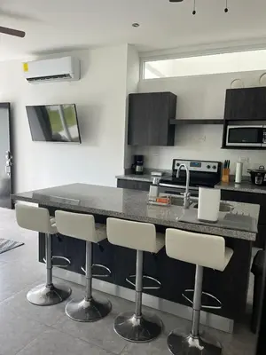 a kitchen with a counter and bar stools at Lapa Lodge G1 in Jacó