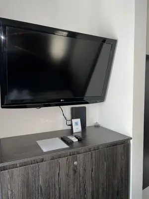 a flat screen tv on top of a wooden cabinet at Lapa Lodge G1 in Jacó