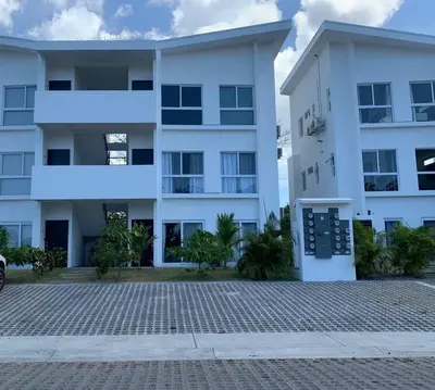a large white apartment building with a parking lot at Lapa Lodge G1 in Jacó