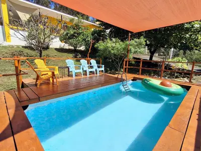 a swimming pool with chairs and an umbrella at La Casa del Conde in Playa Naranjo