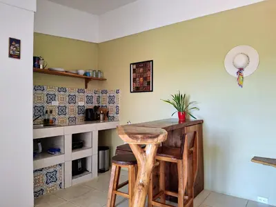 a kitchen with a table and stools in a room at La Casa del Conde in Playa Naranjo