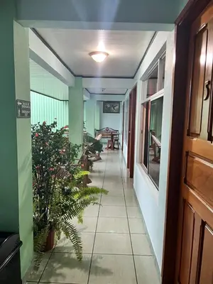 a hallway of a building with a table and chairs at Hotel FAS in Fortuna