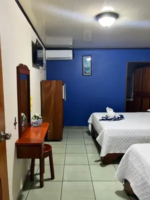 a room with two beds and a blue wall at Hotel FAS in Fortuna