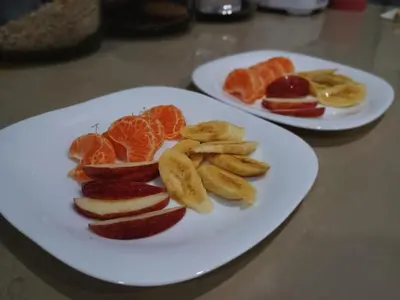 two white plates of fruit on a table at Hotel Serendipity in Tortuguero