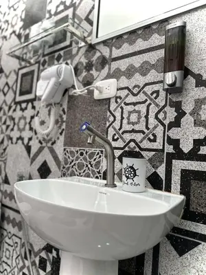 a white sink in a bathroom with tiles at Hotel Serendipity in Tortuguero
