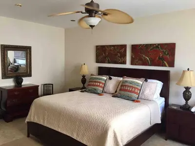 a bedroom with a bed and a ceiling fan at Beach Front Boutique Condominium in Jacó