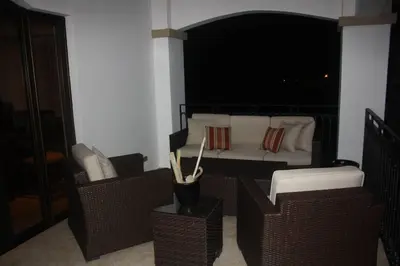 a bedroom with a bed with wicker chairs and a bed at Beach Front Boutique Condominium in Jacó
