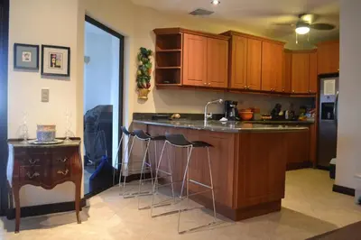 a kitchen with a counter and bar with stools at Beach Front Boutique Condominium in Jacó