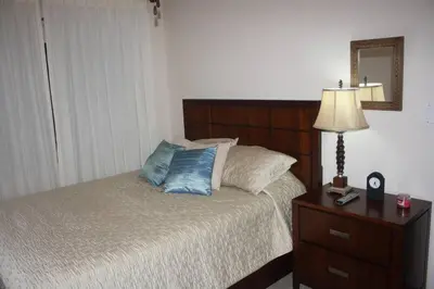 a bedroom with a bed and a lamp and a mirror at Beach Front Boutique Condominium in Jacó