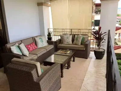 a living room with couches and a table on a balcony at Beach Front Boutique Condominium in Jacó