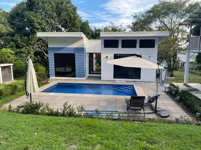 a house with a swimming pool and an umbrella at Loft 45 in Playa Hermosa, paradise near the ocean! in Playa Hermosa