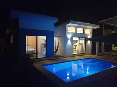 a swimming pool in front of a house at night at Loft 45 in Playa Hermosa, paradise near the ocean! in Playa Hermosa