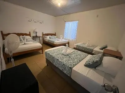 a bedroom with two beds and a window at Casa Artavia in Tortuguero