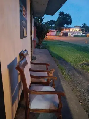 a row of chairs sitting on the side of a building at Casa Artavia in Tortuguero
