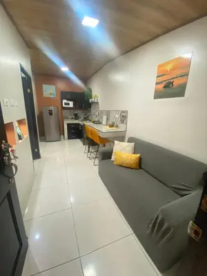 a living room with a couch and a kitchen at Apartamento H Gonzalez 14 free Parking AC wifi in Alajuela City