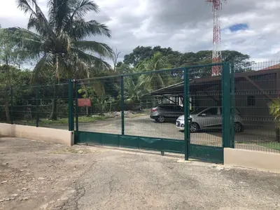 a green gate with cars parked in a parking lot at Apartamento H Gonzalez 14 free Parking AC wifi in Alajuela City