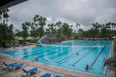 a pool at a resort with people swimming in it at Hotel Suerre in Guápiles
