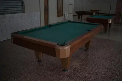 a pool table in a room with two tables at Hotel Suerre in Guápiles