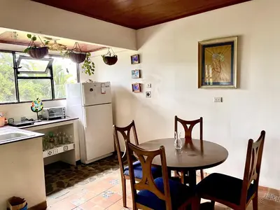 a kitchen with a table and a refrigerator at El Ensueño in Ujarrás