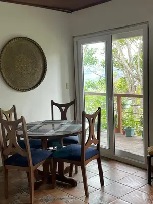 a dining room with a table and chairs and a sliding glass door at El Ensueño in Ujarrás