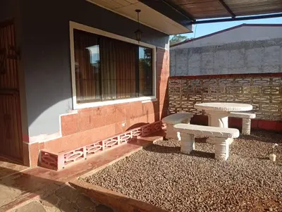 a patio with a table and a bench next to a building at Cabinas Miramar, una casa SOLO para ti in San Isidro