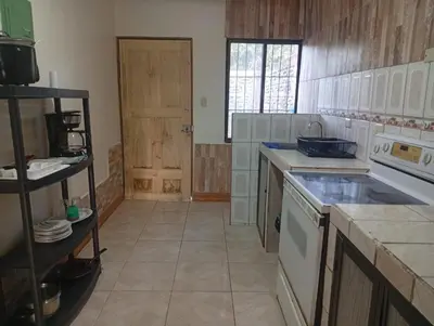a kitchen with a sink and a stove top oven at Cabinas Miramar, una casa SOLO para ti in San Isidro