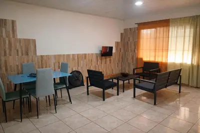 a dining room with a table and chairs and a television at Cabinas Miramar, una casa SOLO para ti in San Isidro