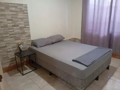 a bed sitting in a room next to a window at Cabinas Miramar, una casa SOLO para ti in San Isidro