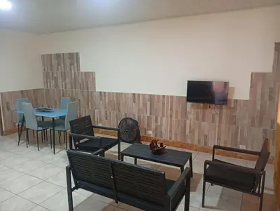 a restaurant with chairs and tables and a tv on a wall at Cabinas Miramar, una casa SOLO para ti in San Isidro