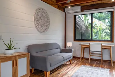 a living room with a chair and a table at Blue Mist Hotel- Adults Only in Santa Teresa Beach