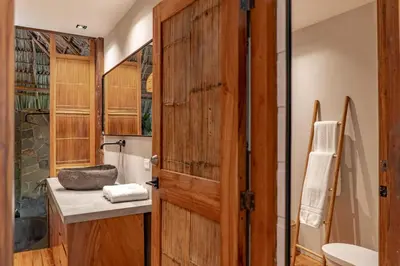 a bathroom with a wooden door and a sink at Blue Mist Hotel- Adults Only in Santa Teresa Beach