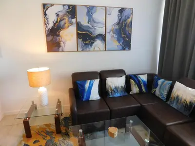 a living room with a couch and a table at Sunset 205, sleeps six, next door to the pool, 100m to the beach! in Jacó