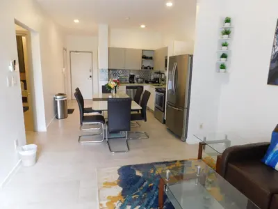 a living room with a table and chairs and a kitchen at Sunset 205, sleeps six, next door to the pool, 100m to the beach! in Jacó