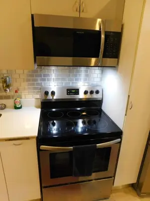a kitchen with a stove and a microwave at Sunset 205, sleeps six, next door to the pool, 100m to the beach! in Jacó