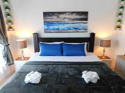 a bedroom with a large bed with blue pillows at Sunset 205, sleeps six, next door to the pool, 100m to the beach! in Jacó