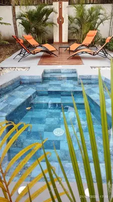a swimming pool with two chairs and a swimming pool at Hotel Tabasco in Playa Flamingo